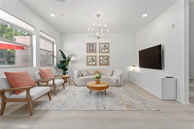 living room with a notable chandelier and light hardwood / wood-style floors