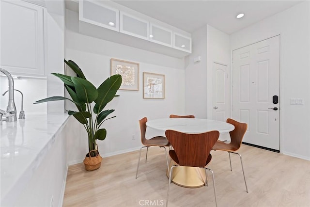 dining room with sink and light hardwood / wood-style flooring