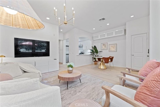 living room featuring a notable chandelier and light hardwood / wood-style flooring