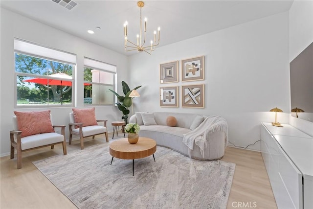 living area featuring an inviting chandelier and light wood-type flooring