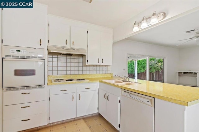 kitchen with white cabinetry, white appliances, kitchen peninsula, and sink