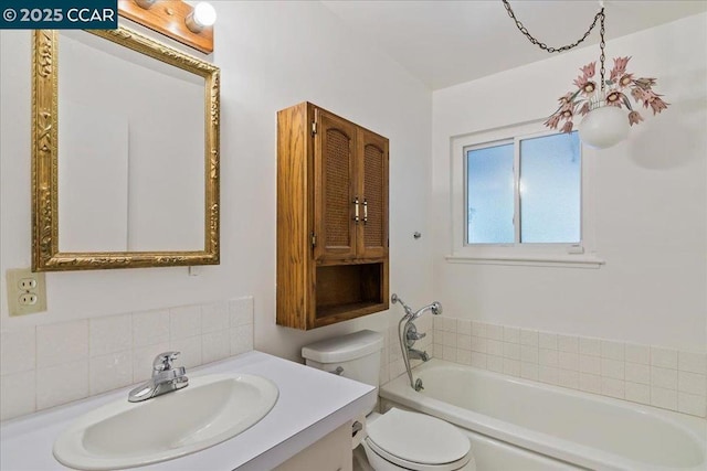 bathroom featuring tasteful backsplash, vanity, a washtub, and toilet