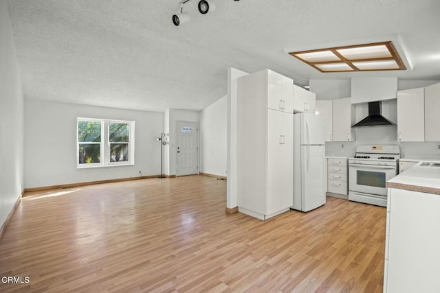 kitchen featuring white cabinets, white appliances, wall chimney exhaust hood, a textured ceiling, and light hardwood / wood-style flooring