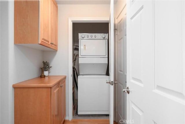 clothes washing area featuring stacked washer and dryer