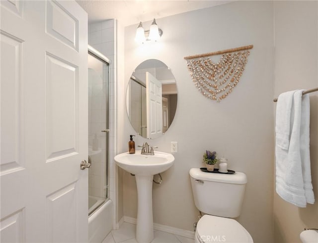 full bathroom with shower / bath combination with glass door, tile patterned floors, toilet, and sink