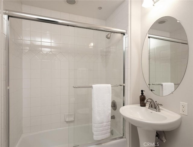 bathroom featuring sink and shower / bath combination with glass door