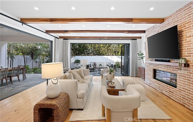 living area featuring beamed ceiling, a fireplace, wood finished floors, and recessed lighting