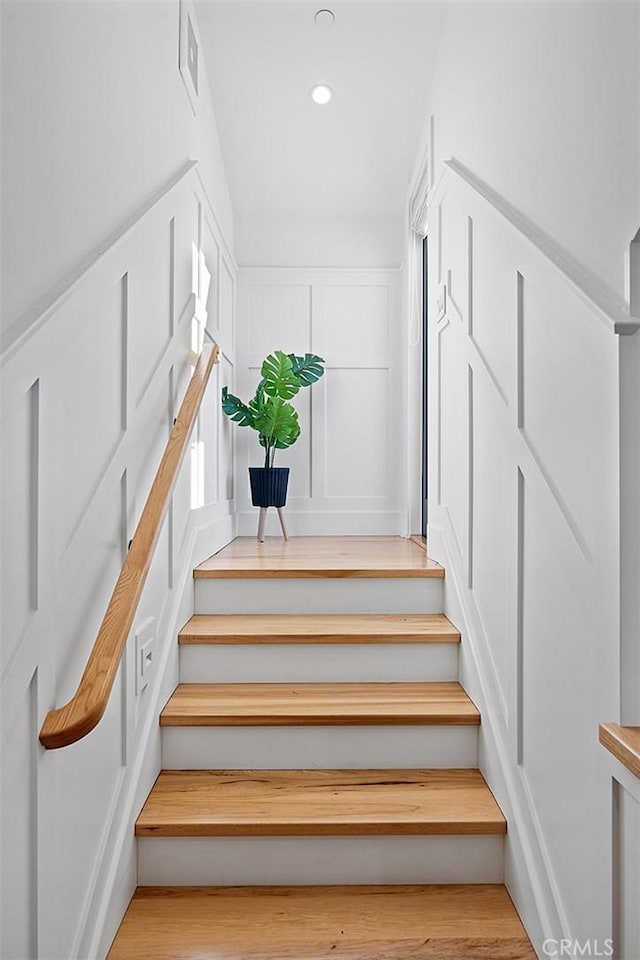 staircase featuring wood finished floors, visible vents, and recessed lighting