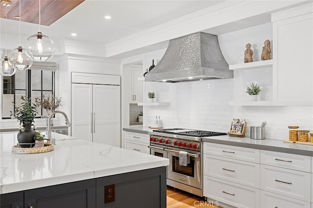 kitchen with white cabinets, wall chimney range hood, high quality appliances, and open shelves