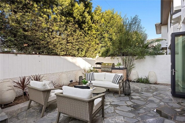 view of patio with area for grilling, an outdoor living space, and a grill