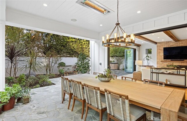 dining space featuring beamed ceiling and an inviting chandelier