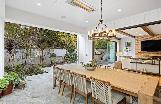 dining area featuring recessed lighting, beam ceiling, stone finish flooring, and an inviting chandelier