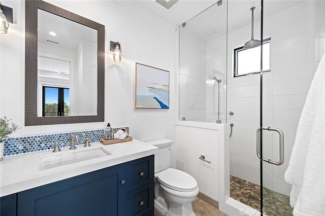 bathroom featuring vanity, plenty of natural light, toilet, and walk in shower