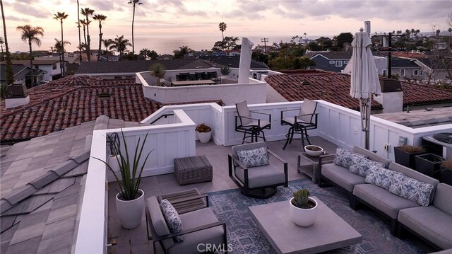 patio terrace at dusk featuring an outdoor living space with a fire pit