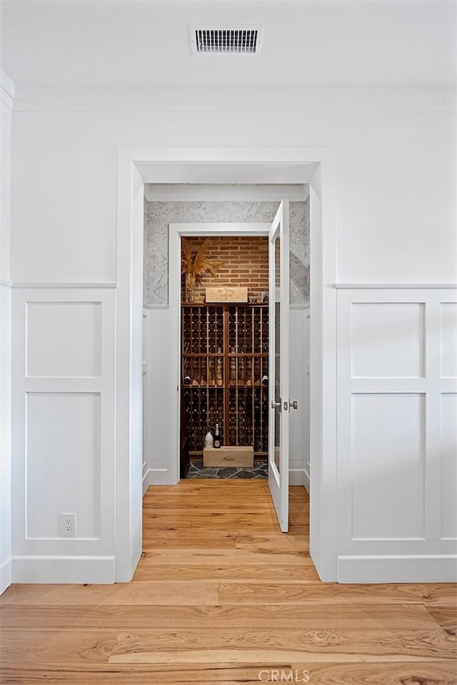 wine room featuring crown molding and light hardwood / wood-style floors