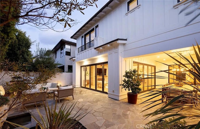 back of house featuring a balcony, a patio area, and an outdoor hangout area