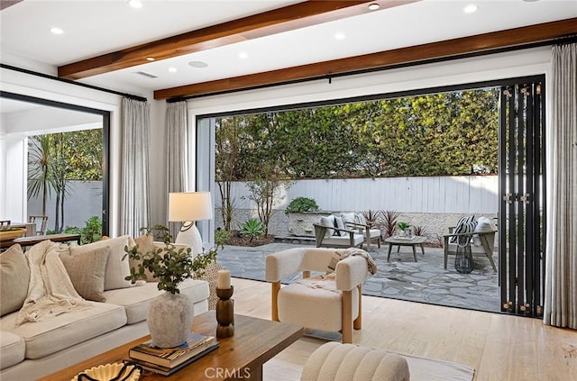 interior space with beam ceiling and light hardwood / wood-style flooring