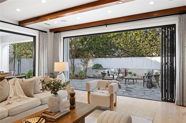 living room featuring visible vents, beamed ceiling, and wood finished floors