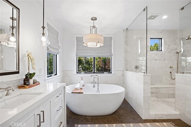 bathroom with tile walls, vanity, and separate shower and tub