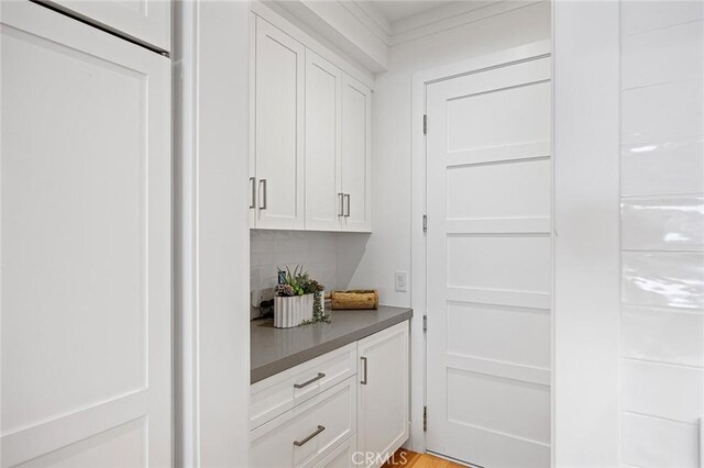 bar featuring tasteful backsplash and white cabinets