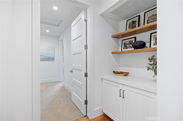 hallway featuring baseboards, recessed lighting, attic access, and light colored carpet