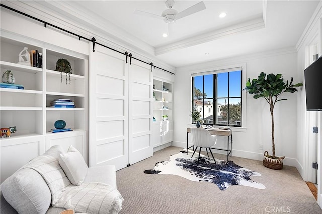 living area with a tray ceiling, a barn door, ornamental molding, light carpet, and baseboards