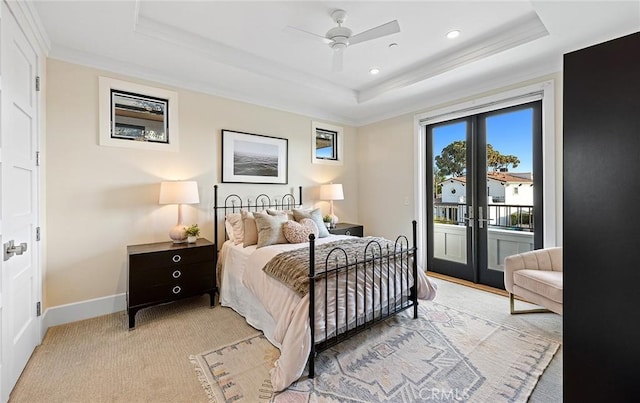 bedroom featuring ceiling fan, access to exterior, a tray ceiling, light colored carpet, and french doors