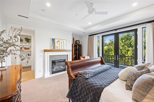 bedroom with a raised ceiling, access to outside, multiple windows, and french doors