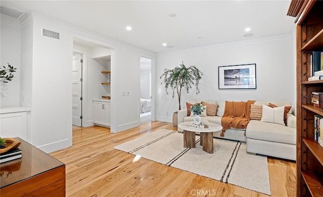 living room with ornamental molding and light wood-type flooring