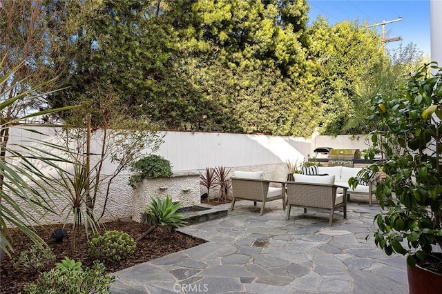 view of patio with an outdoor hangout area, grilling area, an outdoor kitchen, and a fenced backyard