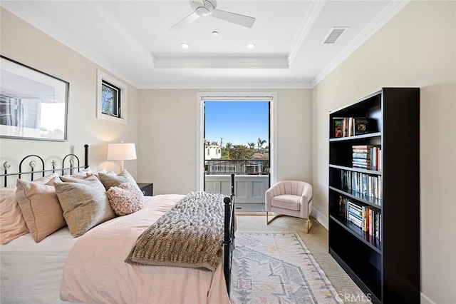 bedroom with light carpet, visible vents, a ceiling fan, ornamental molding, and a tray ceiling