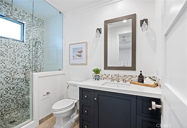 bathroom with a shower with shower door, tasteful backsplash, vanity, ornamental molding, and toilet