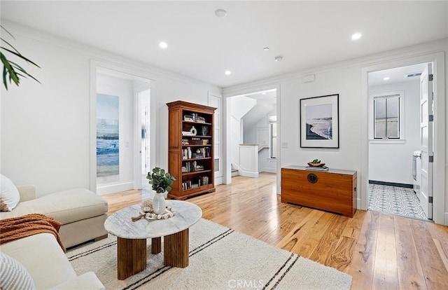 living room featuring ornamental molding and light hardwood / wood-style flooring