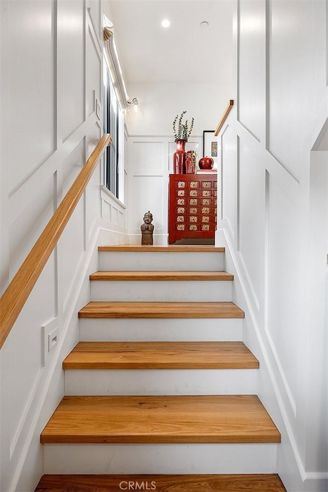 staircase with recessed lighting and a decorative wall