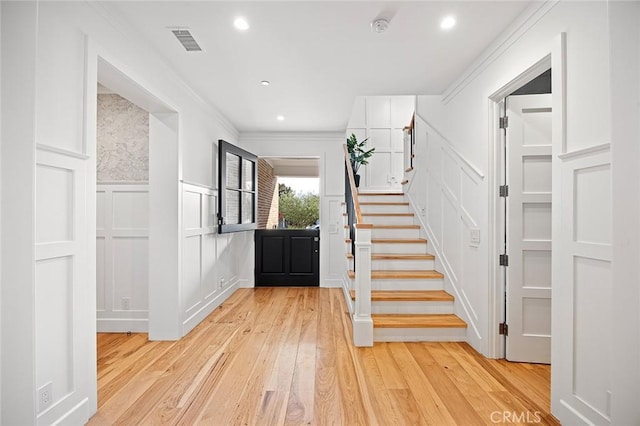 entryway featuring crown molding and light hardwood / wood-style flooring