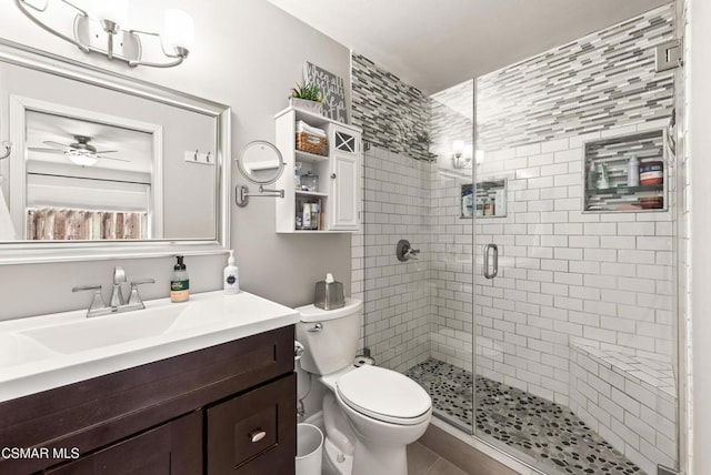 bathroom featuring vanity, ceiling fan, toilet, and walk in shower