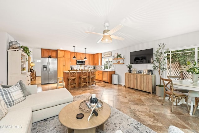 living room with sink, a healthy amount of sunlight, and ceiling fan