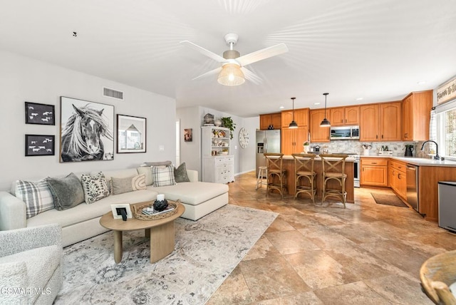 living room with ceiling fan and sink