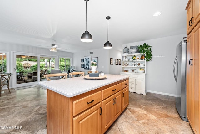 kitchen featuring hanging light fixtures, a center island, stainless steel fridge, and ceiling fan