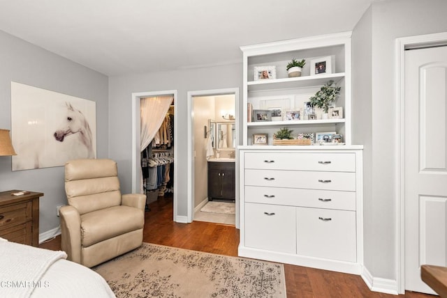 bedroom featuring connected bathroom, a spacious closet, hardwood / wood-style floors, and a closet