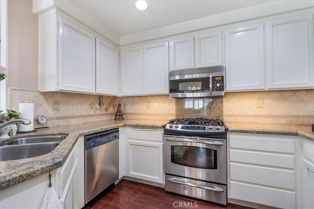 kitchen featuring light stone counters, sink, white cabinets, and appliances with stainless steel finishes