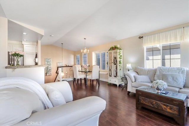 living room with an inviting chandelier, dark wood-type flooring, and vaulted ceiling