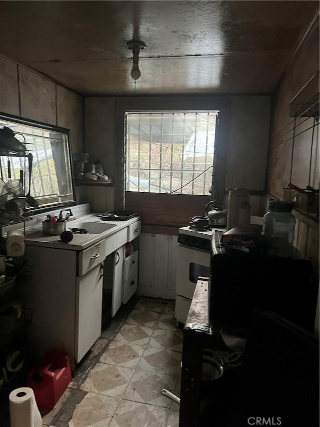 kitchen featuring sink, white cabinets, and white stove