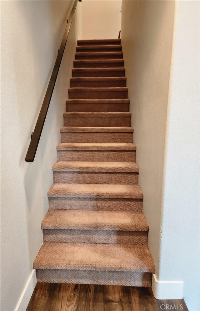 stairs featuring hardwood / wood-style floors