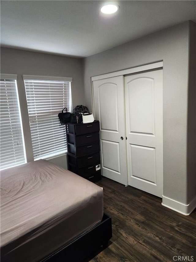 bedroom with dark wood-type flooring and a closet