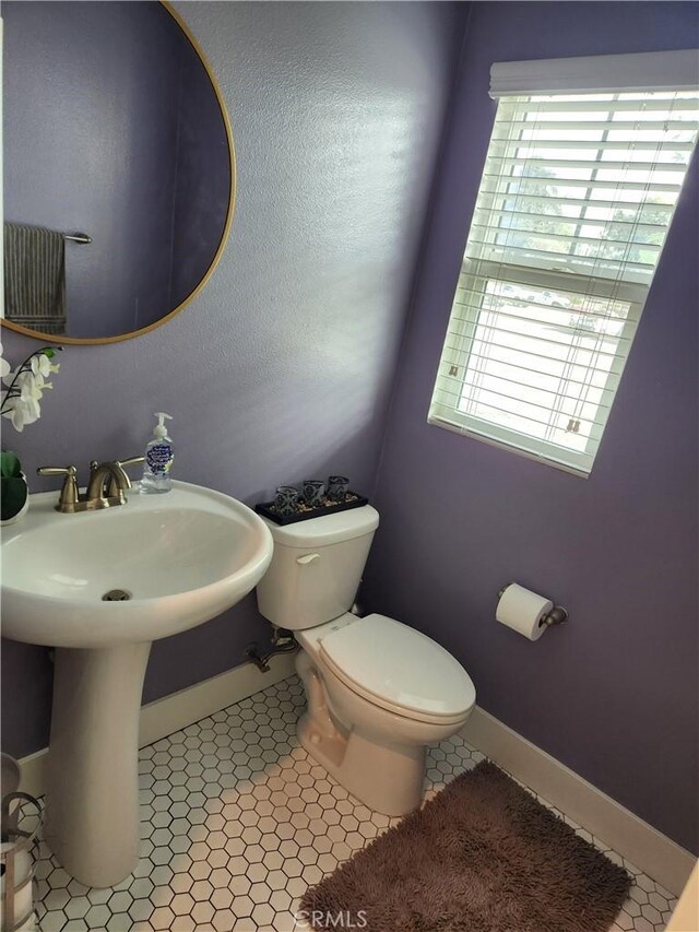 bathroom featuring a healthy amount of sunlight, sink, tile patterned floors, and toilet