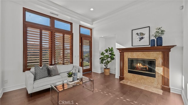 living room featuring ornamental molding, dark hardwood / wood-style flooring, and a premium fireplace