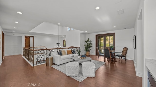 living room featuring an inviting chandelier and dark hardwood / wood-style flooring