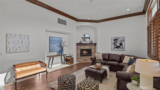 living room with a fireplace, crown molding, and light hardwood / wood-style flooring