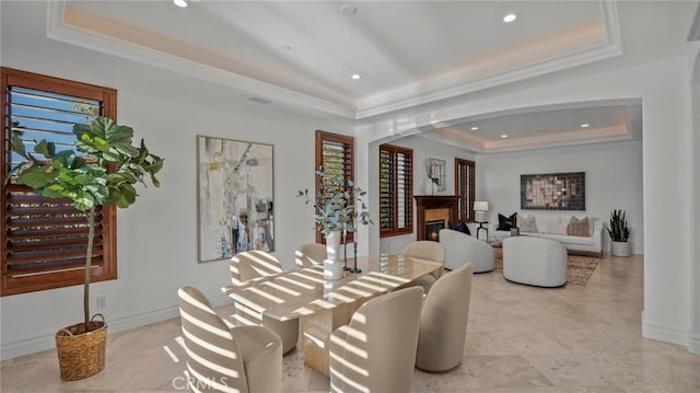 dining room featuring crown molding and a raised ceiling